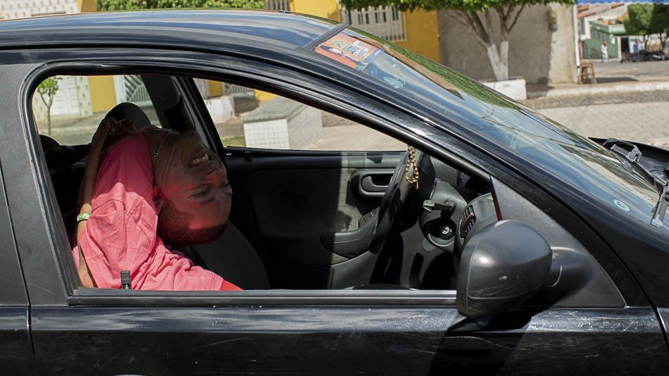 A woman is sleeping in the driver 's seat of a car.