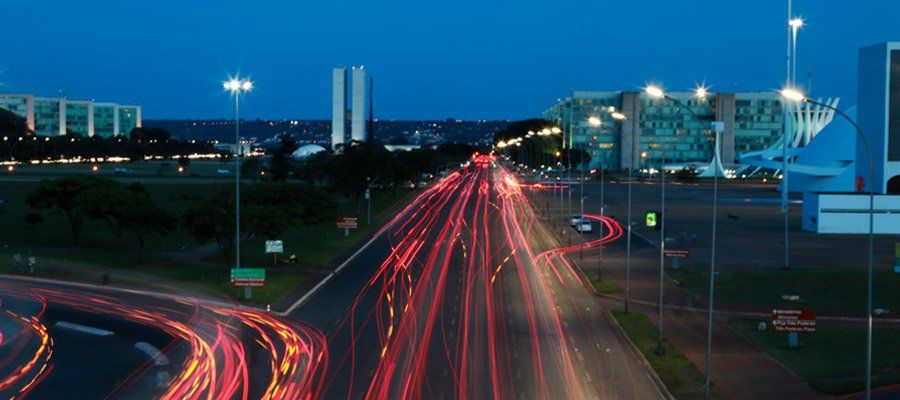 A long exposure photo of a highway at night with a city in the background.