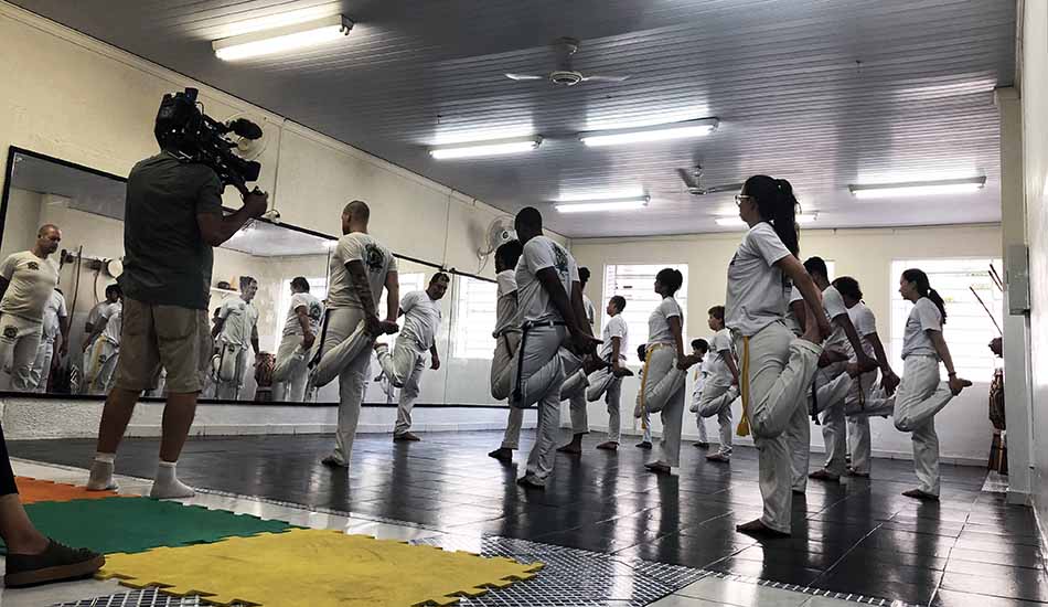 A group of people are doing stretching exercises in a gym.