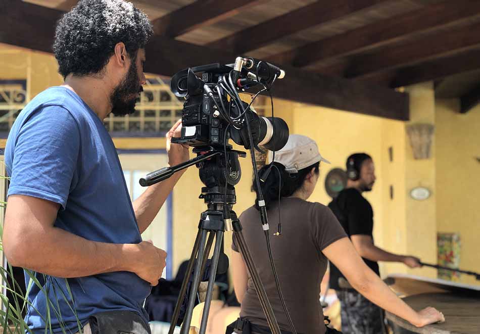 A man and a woman are standing in front of a camera.