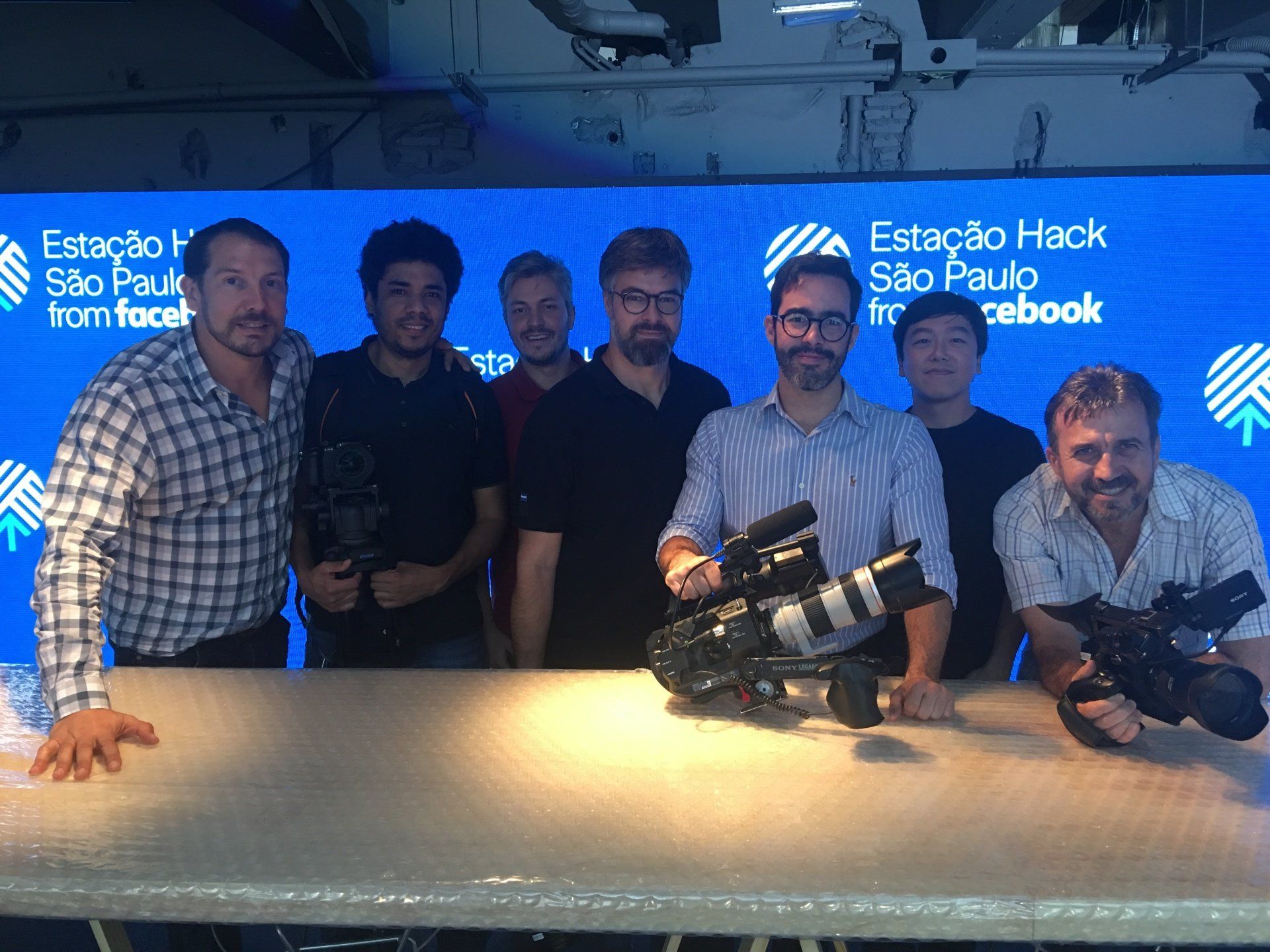 A group of men standing around a table with cameras