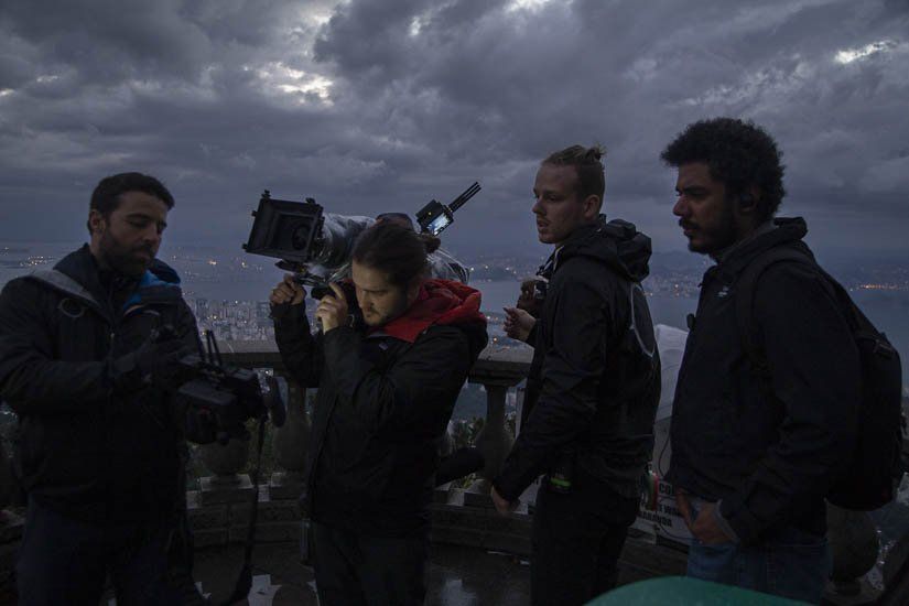 A group of people are standing around a camera.
