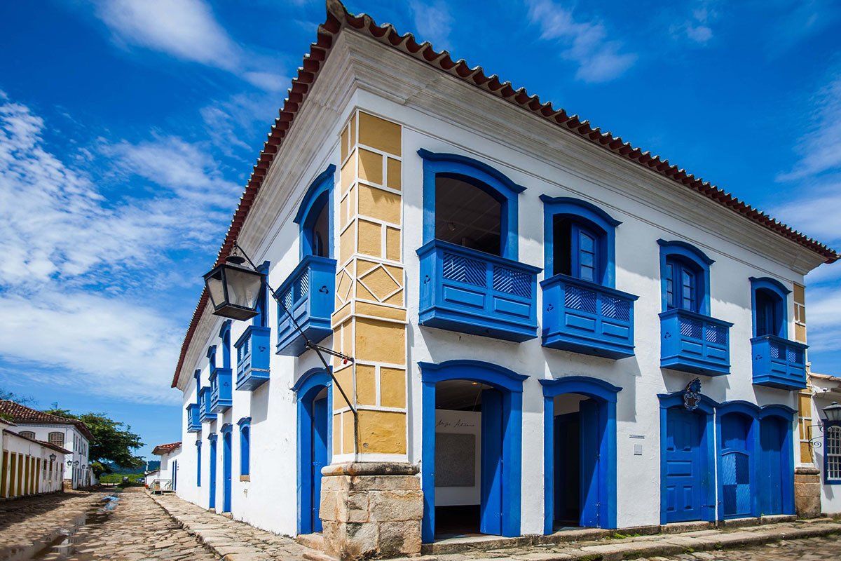A white building with blue balconies on a sunny day.