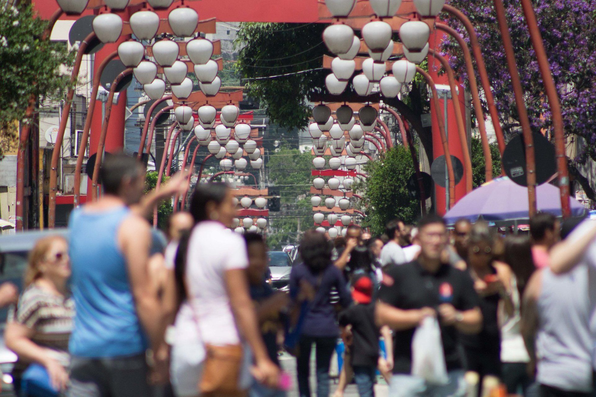 A crowd of people are walking down a street in a city.