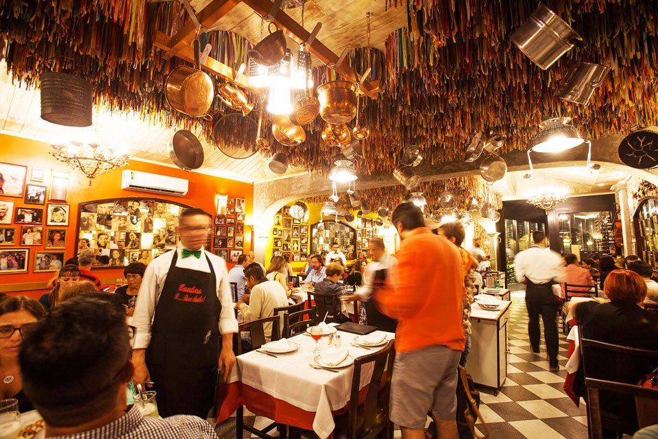 A restaurant with a lot of pots and pans hanging from the ceiling