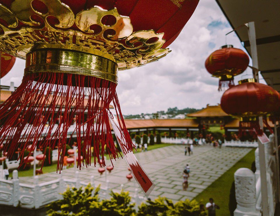 A bunch of red lanterns are hanging from the ceiling of a building