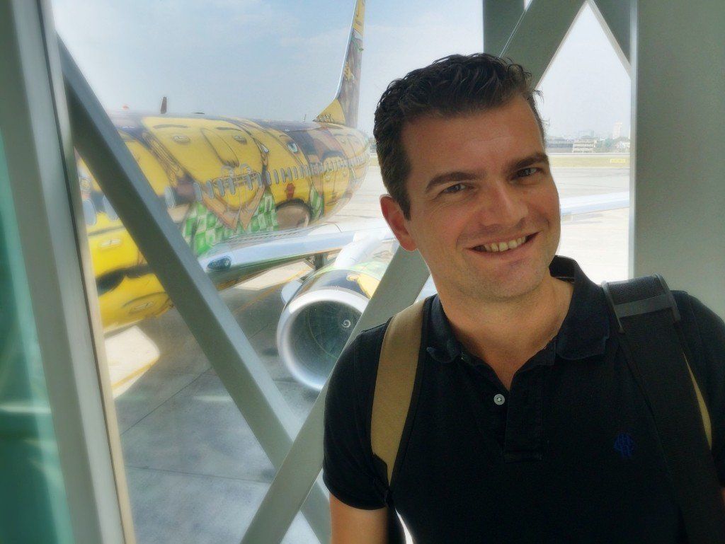 A man is standing in front of a yellow airplane that says jetstar