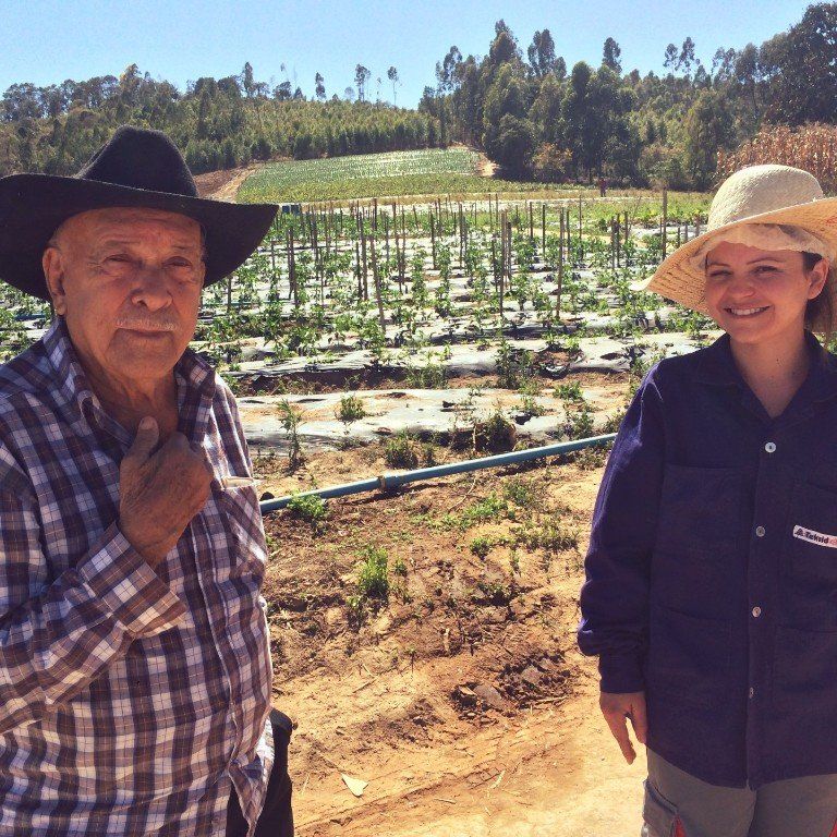 A man and a woman standing in front of a field