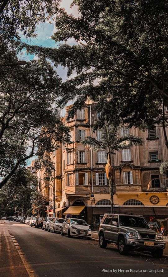 Photo by Heron Rossato on Unsplash A row of cars are parked on the side of a city street.