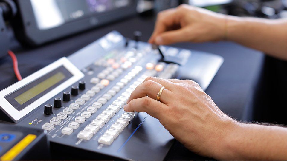 Story Productions crew transmiting live from set A person is typing on a keyboard with a ring on their finger.