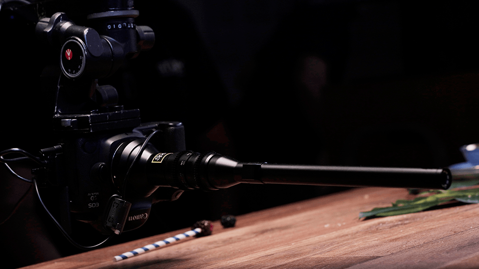 A camera is sitting on top of a wooden table.