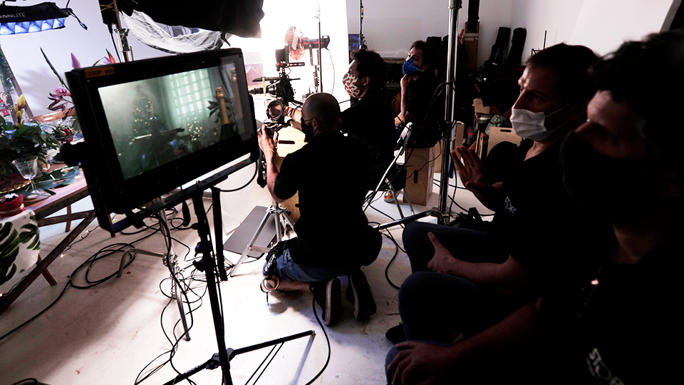 A group of people are sitting in front of a screen in a room.