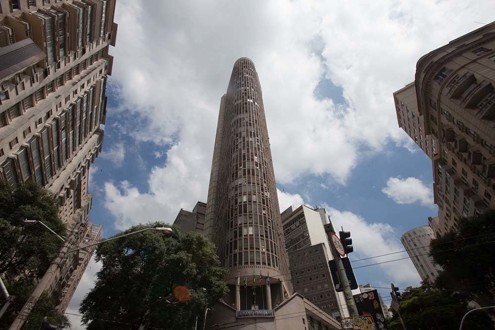 Looking up at a tall building in the middle of a city