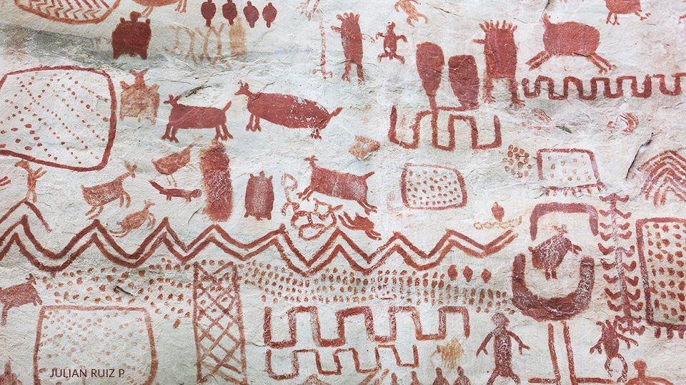 Mural painting at Serrania la Lindosa A close up of a painting of animals and people on a wall.
