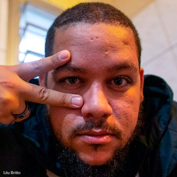 A man with a beard is making a peace sign with his finger