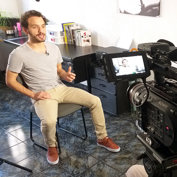 The Story Productions crew films on location A man is sitting in front of a sony camera