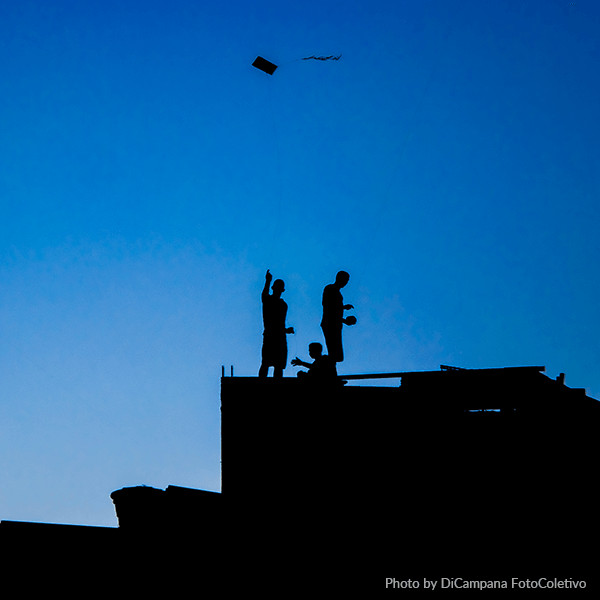 Photo by DiCampana Colectivo A group of people standing on top of a building with a blue sky in the background