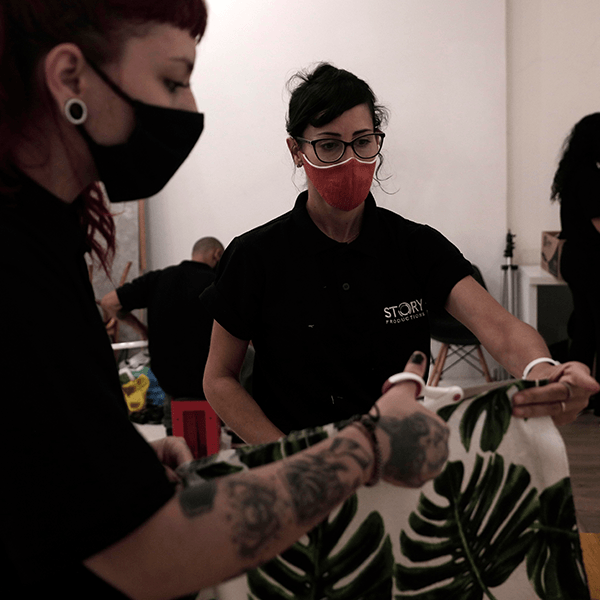 A woman wearing a mask has the word story on her shirt