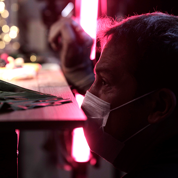 A man wearing a mask is looking at something