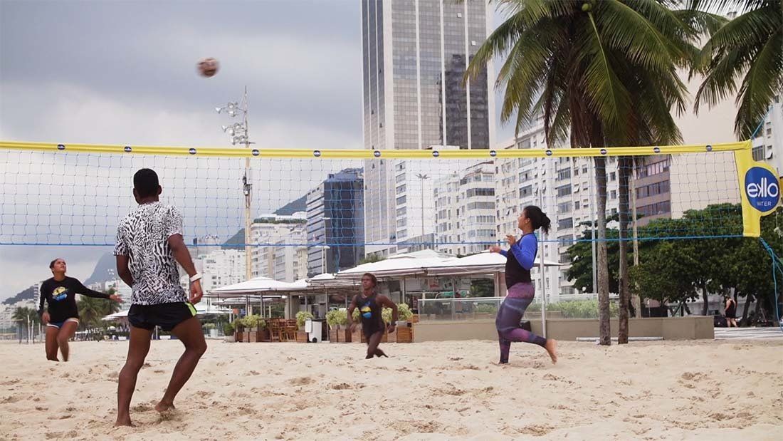 A group of people are playing volleyball on a beach.