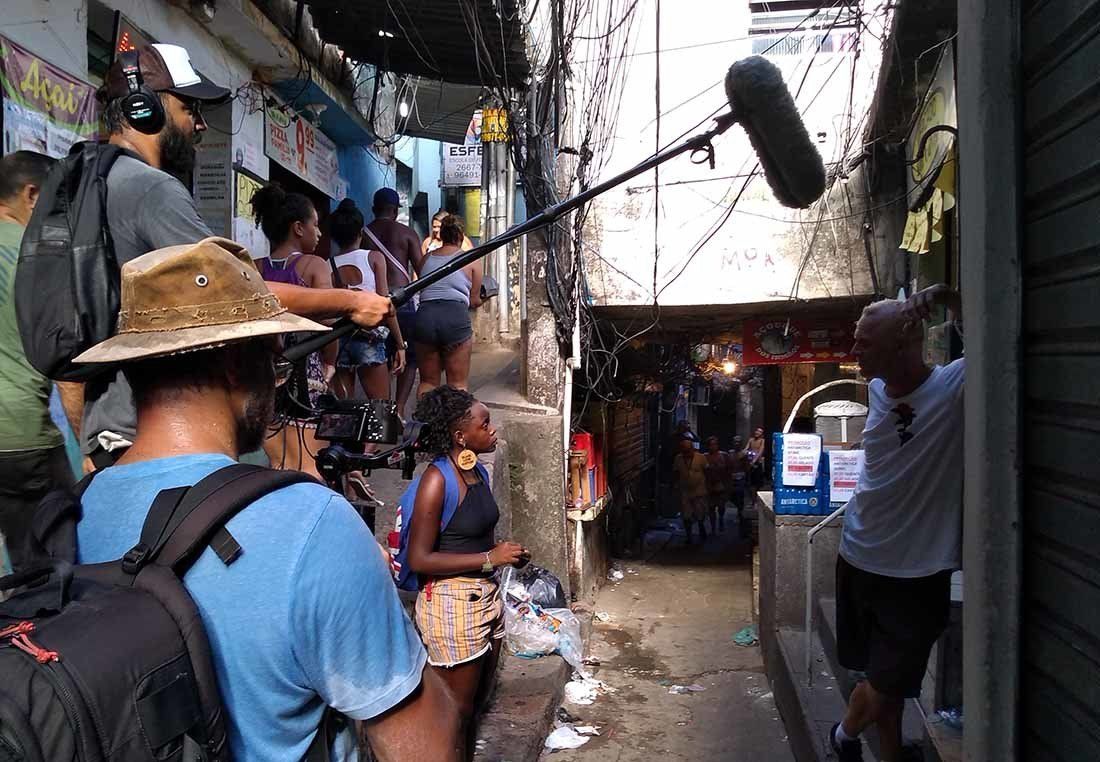 A group of people are standing in a narrow alleyway with a microphone.