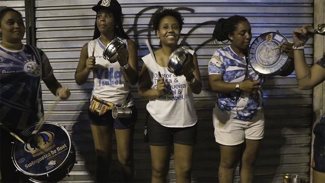 A group of women are standing next to each other holding drums.