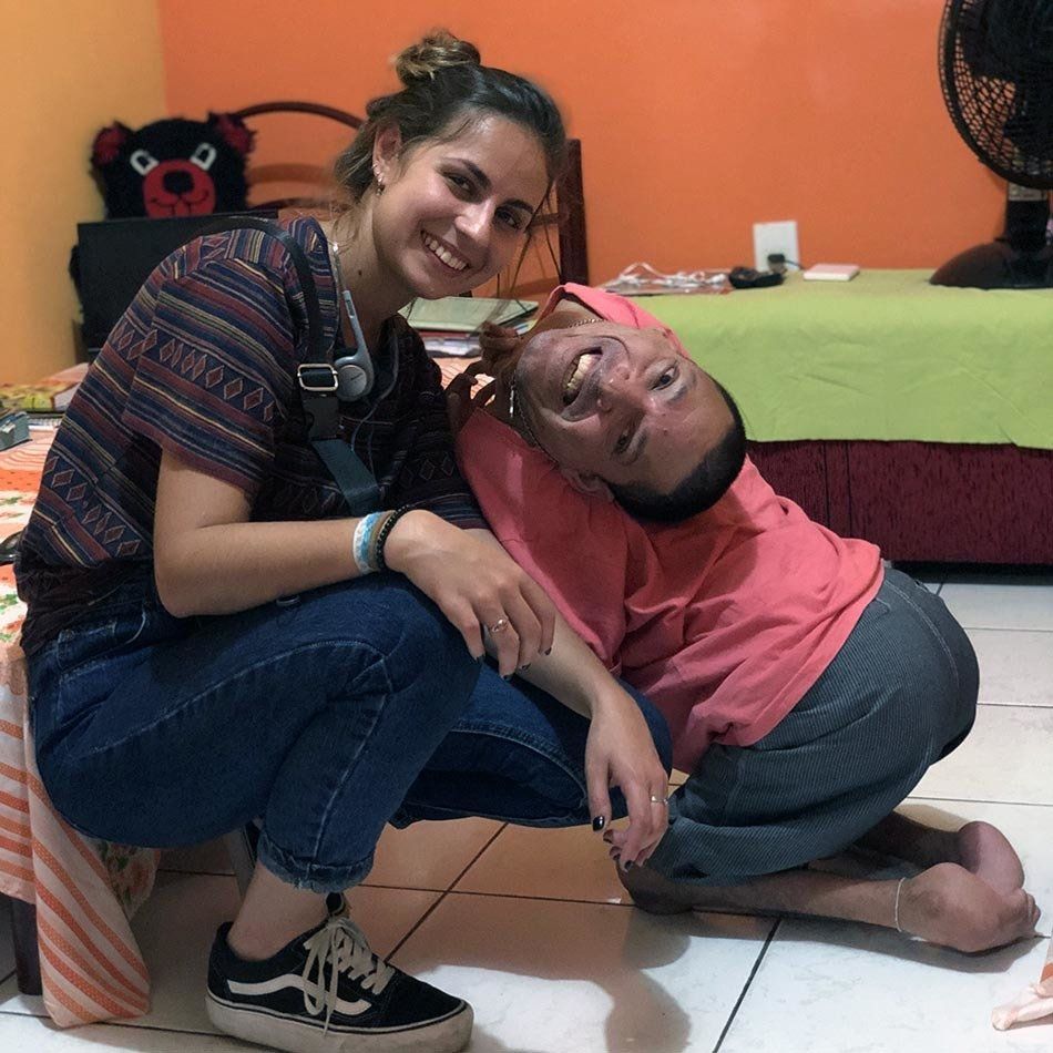 A man and a woman are posing for a picture in a bedroom