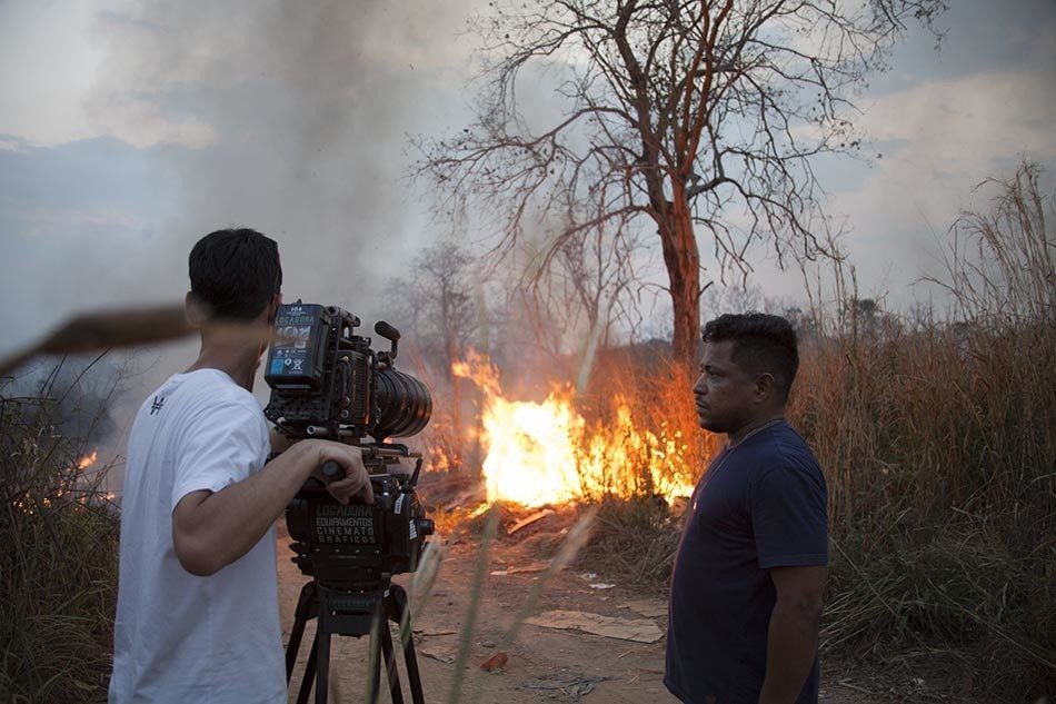 A man is taking a picture of a fire with a camera.
