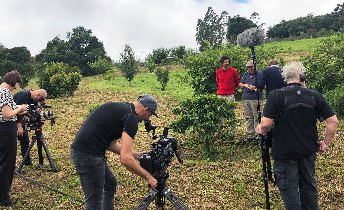 A group of people are standing in a field with cameras.