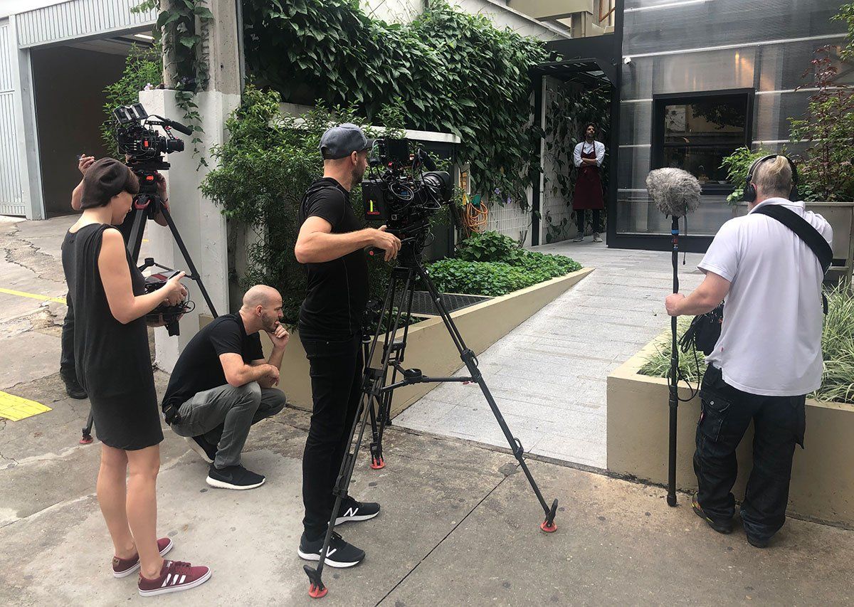 Chef Ivan Ralston in his restaurant Tuju in São Paulo A group of people are standing around a camera on a tripod.