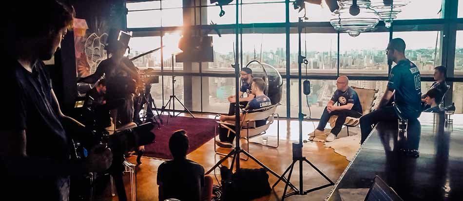 A group of people are sitting in front of a camera in a room.
