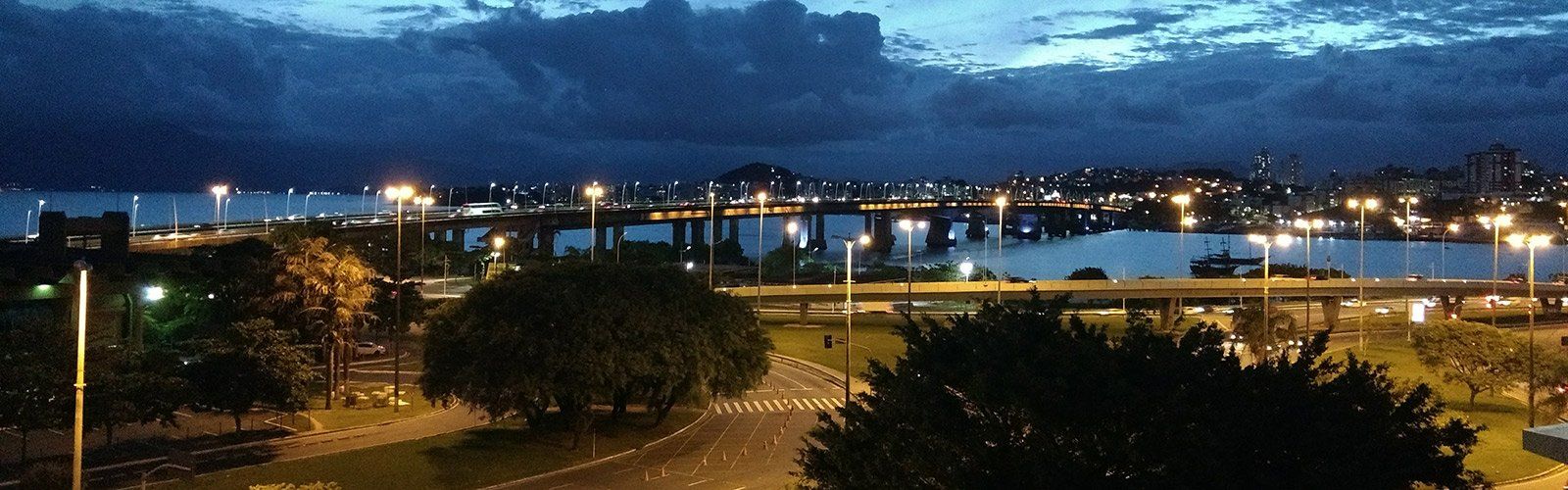 An aerial view of a city at night with a bridge over a body of water.