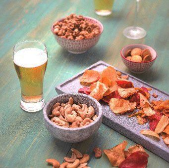 A table topped with bowls of food and a glass of beer.