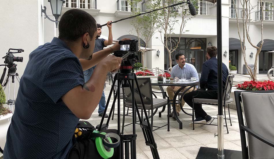 A man is taking a picture of a group of people sitting at a table.