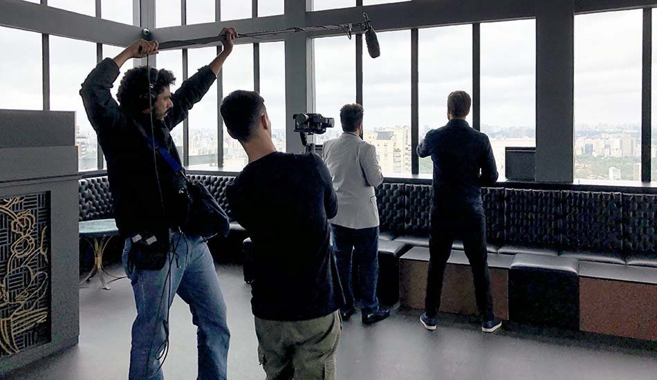 A group of men are standing in front of a large window.