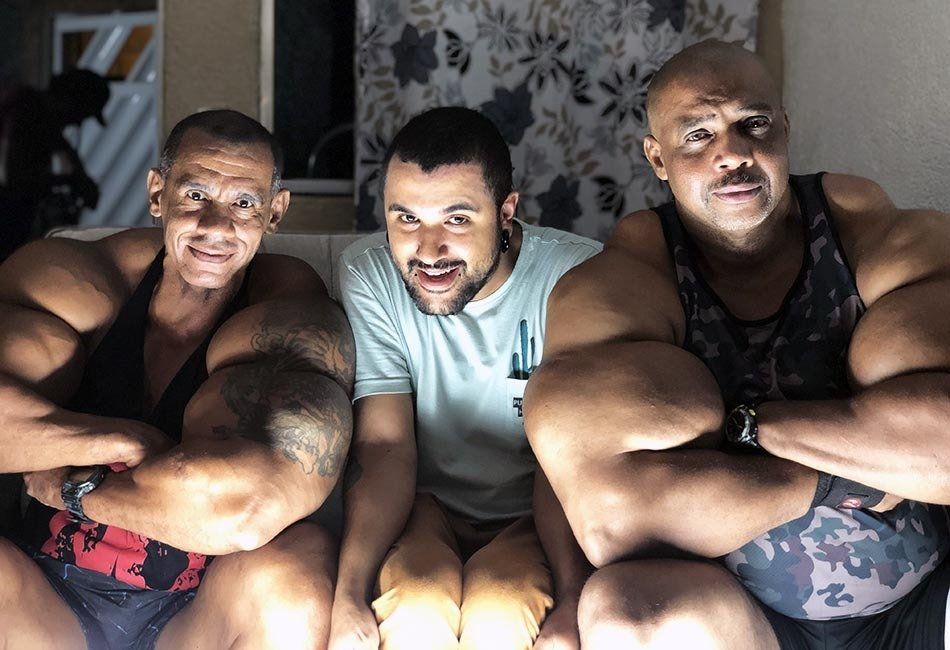Three muscular men are posing for a picture with their arms crossed.