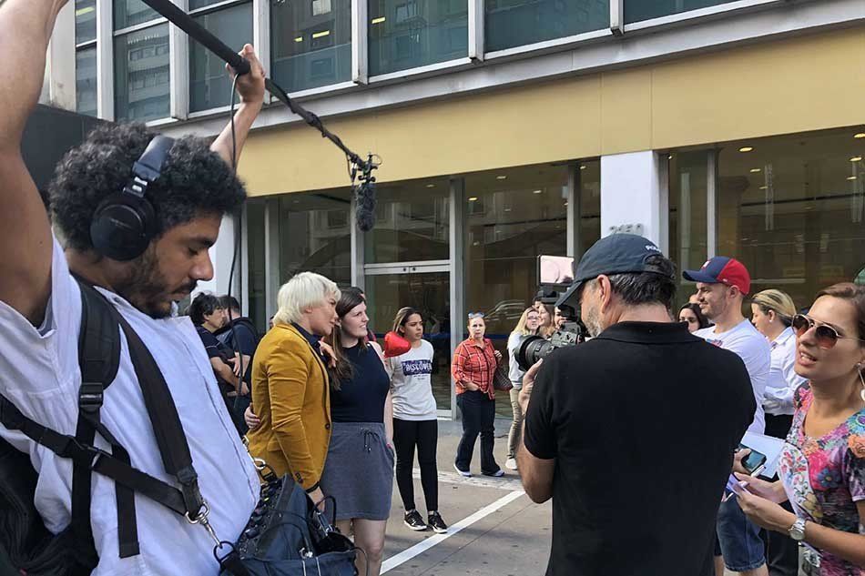 A man is holding a microphone in front of a group of people.