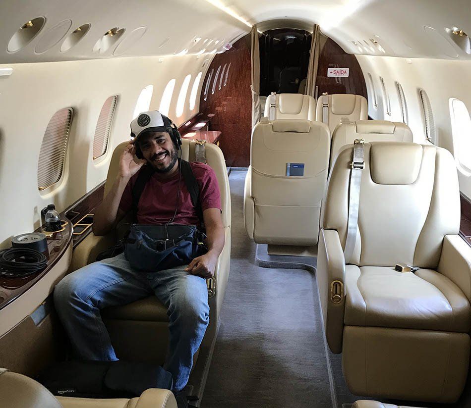 A man wearing headphones is sitting on a plane