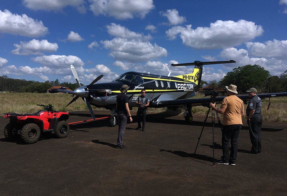A group of people are standing in front of a small plane with the letters rlm on the tail