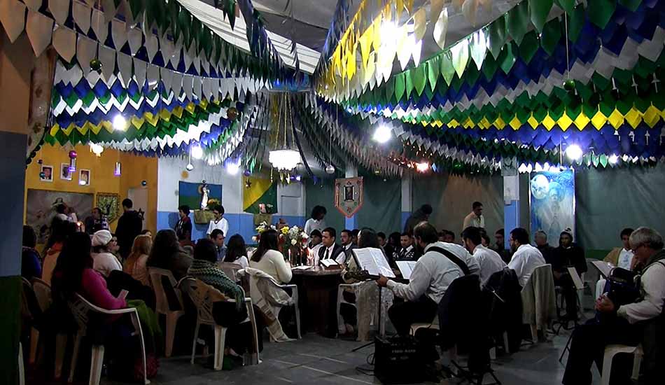 A group of people are sitting around a table in a room with flags hanging from the ceiling.