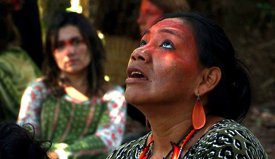 A woman with red paint on her face is looking up at the sky.
