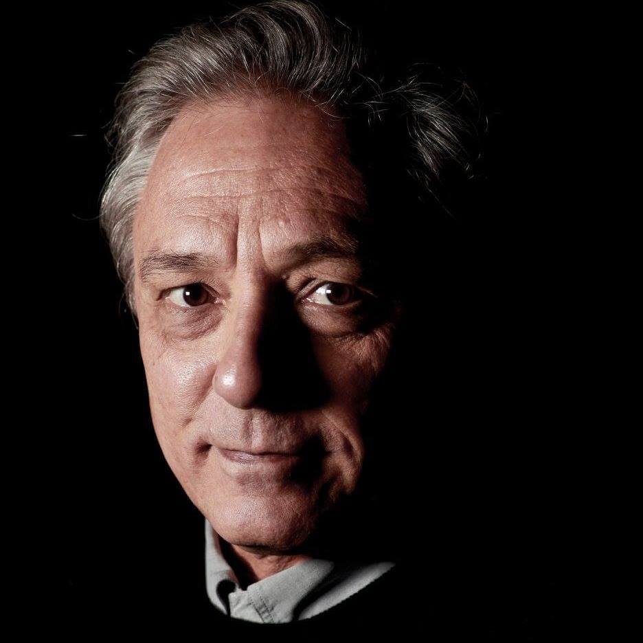 A close up of a man 's face with a black background