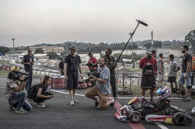 A group of people are standing around a go kart.
