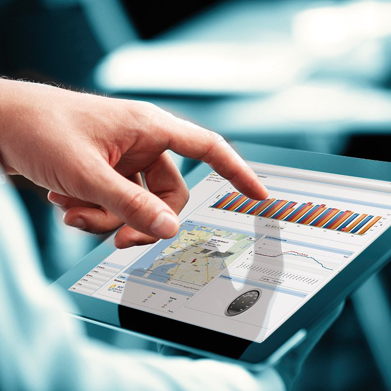 Hand die een tablet gebruikt waarop een kaart en een kleurendiagram worden weergegeven in een lichte kantooromgeving.