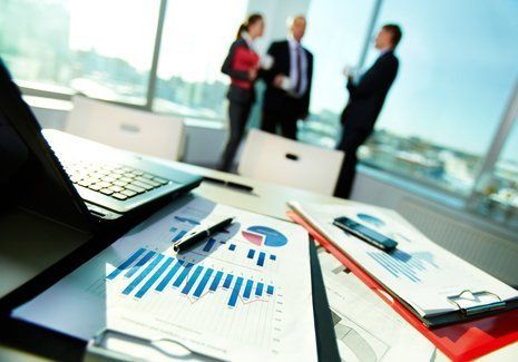 fogli con grafici vicino il computer di un consulente del lavoro
