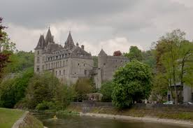 Een groot kasteel omgeven door bomen en een rivier.