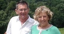 Een man en een vrouw poseren voor een foto voor een bos.