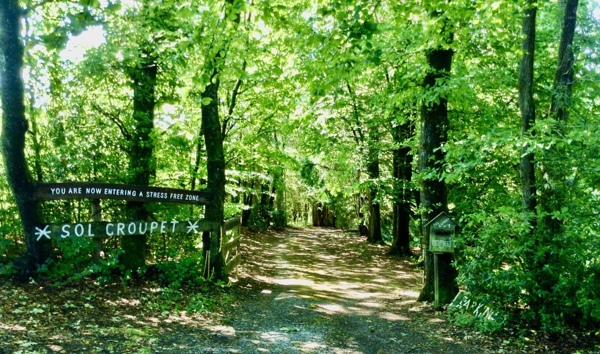 Een pad in het bos met een bordje waarop staat sol croquet