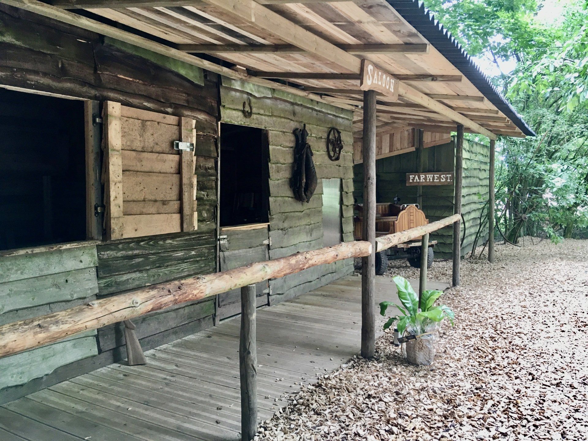 Een houten gebouw met een overdekte veranda en een houten balustrade.