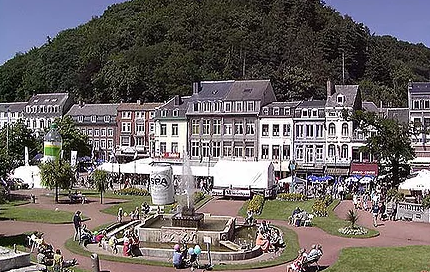 Een groep mensen zit rond een fontein in een park.